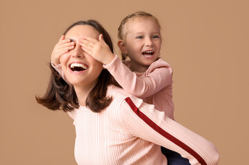 Canvas Print - Beautiful mother with her cute little daughter having fun together on brown background