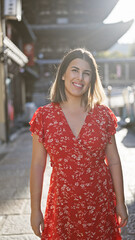 Sticker - Beautiful hispanic woman smiling joyfully, confidently posing, standing on the old traditional streets of gion, kyoto, her sunny, carefree nature shining through for a fun-filled japan adventure.