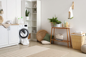 Poster - Interior of stylish laundry room with washing machine, houseplants and cleaning supplies