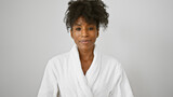 Fototapeta  - African american woman wearing bathrobe standing with serious face over isolated white background