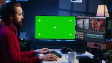 Videographer uses editing software on green screen computer to assemble footage into cohesive final result. Expert color correcting clips on mockup monitor to ensure project meets desired aesthetic