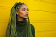 black young woman with long green braids, red lipstick, eyeliner, makeup, earrings, bright yellow background, colorful, afro ethnic style, vivid radiant, fashion brown african american