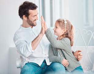 Sticker - Father, girl child and happy with high five, smile and hug with care, love and bonding on chair in home. Dad, kid and cheers with success, support and motivation at family house for celebration