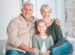 © Nina L/peopleimages.com - Grandparents, girl and portrait on couch, smile or hug for care, bonding or love in home living room. Old man, elderly woman and kid with happy embrace on lounge sofa, relax and pride in family house