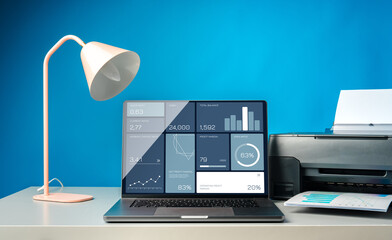 Modern printer with paper and laptop on table in office