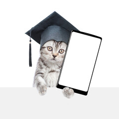 Poster - Сollege graduate kitten holds big smartphone with white blank screen in it paw, showing above empty white banner. isolated on white background