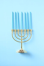 Golden Menorah With Candles On Blue Background. Happy Hanukkah Concept.