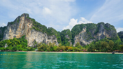 Wall Mural - Beautiful landscape with rocks, cliffs, tropical beach. Krabi, Thailand. Typical long tail boat in Island of Thailand. Railay Beach on a sunny day with clear blue sky.