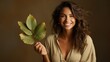 © Алина Бузунова - Beautiful smiling woman with leaf in her hand on dark beige background
