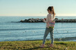 © karlos - Playa de Pedregalejo, Málaga, niña seis años en el césped, frente al mar, escribiendo en su diario, día soleado, cielo sin nubes