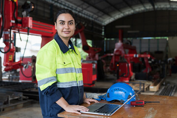 Female engineer inspecting quality and maintenance autonomous robotics arm system welding in factory