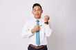 © Bangun Stock Photo - Time is out. Portrait of a serious young employee businessman corporate lawyer Asian wearing a formal shirt tie looking at camera and pointing at his watch isolated on white background