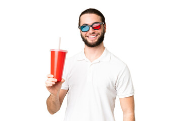 Wall Mural - Young handsome man holding soda while watching a 3D movie over isolated chroma key background smiling a lot