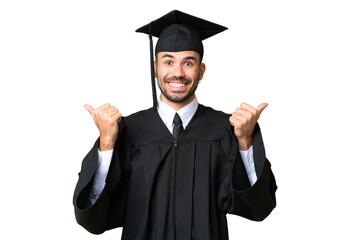 Wall Mural - Young university graduate man over isolated chroma key background with thumbs up gesture and smiling