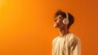 © Oulaphone - Confident young generation z hipster standing alone against an orange background.
