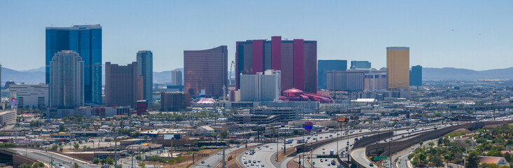 Wall Mural - Vibrant Las Vegas cityscape with modern high-rises, unique architecture, and bustling highways set against a clear sky and distant mountains, showcasing urban evolution and design diversity.