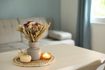 Canvas Print - Beautiful bouquet of dry flowers, small pumpkins and candle on white table indoors, space for text