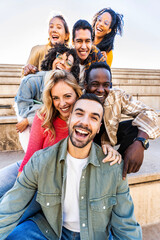 Multi racial friends having fun together on city street - Group of young people smiling at camera outside - Vertical photo