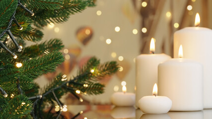 Wall Mural - Celebrating Happy New Year home. Winter holidays concept close-up burning candles. Decorated Christmas tree on background. Evergreen tree bokeh flickering light bulbs garlands. Winter family holiday