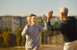 © Studio Romantic - Senior happy couple family giving high five to each other after successful morning workout or jogging exercises outside in city park. Sport in nature and fitness training in retirement concept.