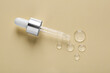 © New Africa - Pipette with samples of cosmetic serum on beige background, flat lay