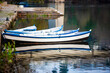 quatro barcos azuis e brancos na margem do rio. ambiente de outono inverno, margens em pedra antiga, reflexo dos barcos na água .