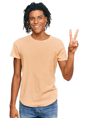 Wall Mural - Young african american man wearing casual clothes showing and pointing up with fingers number two while smiling confident and happy.