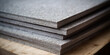 Thick grey cardboard made from recycled pulp or pressed sawdust for construction, interior wall cladding and insulation. Stack of thick cardboard dsp from recycled paper for floor and wall cladding.