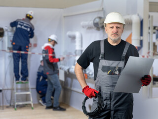 Poster - industrial engineer. man technologist is standing in workshop. guy engineer with working document. i