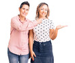 © Krakenimages.com - Couple of women wearing casual clothes amazed and smiling to the camera while presenting with hand and pointing with finger.
