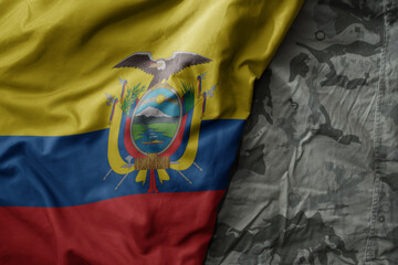 Wall Mural - waving flag of ecuador on the old khaki texture background. military concept.