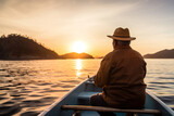 Senior fisherman in hat rowing boat at sunset on tranquil lake