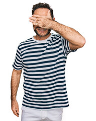 Wall Mural - Middle age man wearing casual clothes and glasses smiling and laughing with hand on face covering eyes for surprise. blind concept.