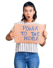 Sticker - Young woman holding power to the people banner scared and amazed with open mouth for surprise, disbelief face