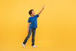 © Prostock-studio - Black boy reaching up, blue tee, yellow background