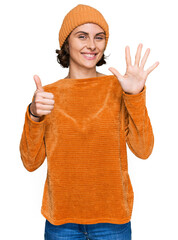 Poster - Young hispanic woman wearing casual clothes and wool cap showing and pointing up with fingers number six while smiling confident and happy.