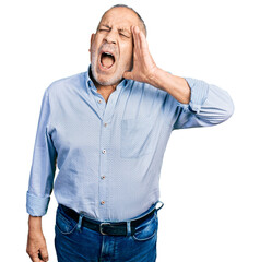 Canvas Print - Senior man with grey hair and beard wearing casual blue shirt shouting and screaming loud to side with hand on mouth. communication concept.