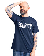 Canvas Print - Young handsome man wearing security t shirt smiling confident touching hair with hand up gesture, posing attractive and fashionable