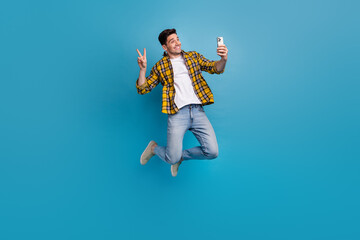 Poster - Full body size photo of funky businessman blogging using smartphone recording vlog shows v sign in air isolated on blue color background