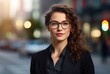 © IgnacioJulian - businesswoman in glasses standing with arms folded in the city, detailed facial features
