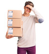 © Krakenimages.com - Young handsome man holding delivery package stressed and frustrated with hand on head, surprised and angry face
