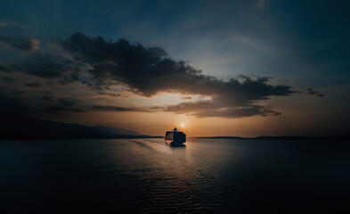 large cargo ship with containers sails on the sea at sunset. Transporting cargo by sea