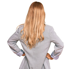 Poster - Beautiful blonde young woman wearing business clothes standing backwards looking away with arms on body