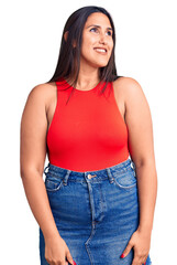 Poster - Young beautiful brunette woman wearing casual sleevelss t-shirt looking away to side with smile on face, natural expression. laughing confident.