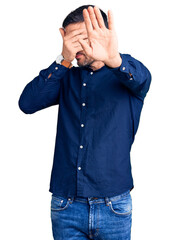 Sticker - Young handsome man wearing casual shirt covering eyes with hands and doing stop gesture with sad and fear expression. embarrassed and negative concept.