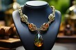 Gold necklace with amber stones on a black stand.