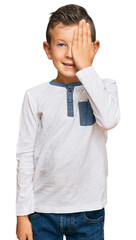 Poster - Adorable caucasian kid wearing casual clothes covering one eye with hand, confident smile on face and surprise emotion.