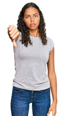 Wall Mural - Young african american girl wearing casual clothes looking unhappy and angry showing rejection and negative with thumbs down gesture. bad expression.