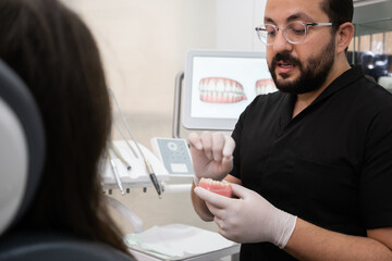 Aufkleber - Bearded dentist with glasses explaining teeth treatment plan to female patient during appointment in medical center stomatologist consulting woman in office