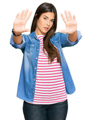 Sticker - Young brunette woman wearing casual clothes doing frame using hands palms and fingers, camera perspective